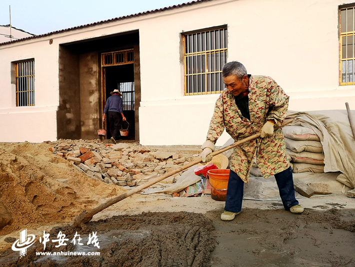 庐江县大同镇的姚则新老人正在和施工队一起干活，重建房屋.jpg